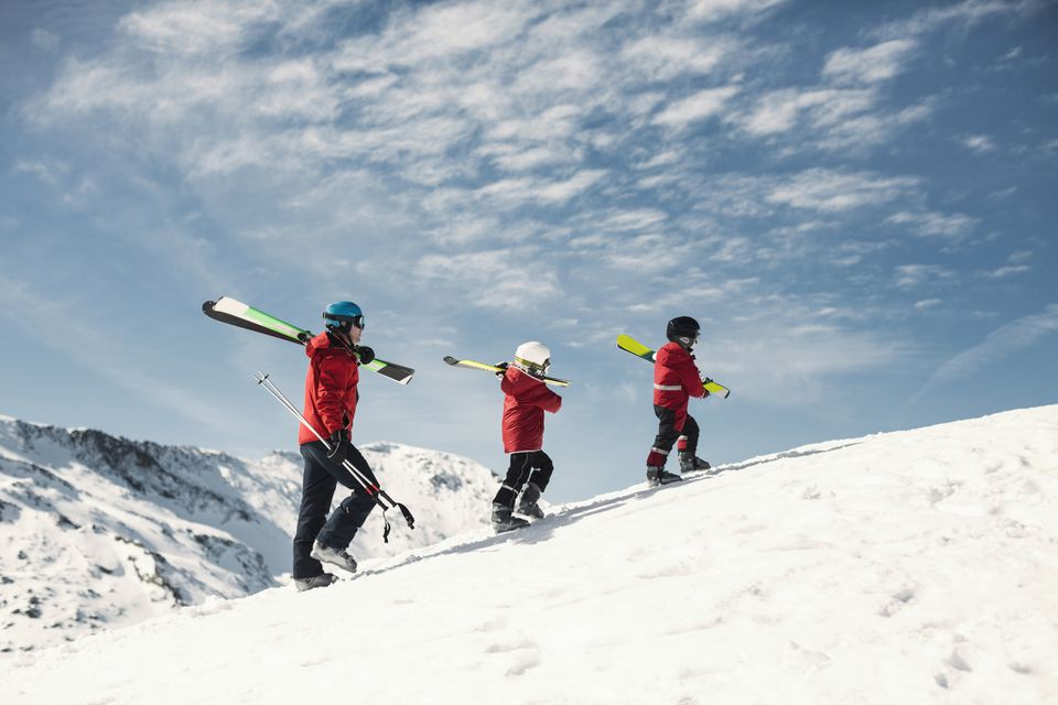 一家人正走在滑雪坡道上