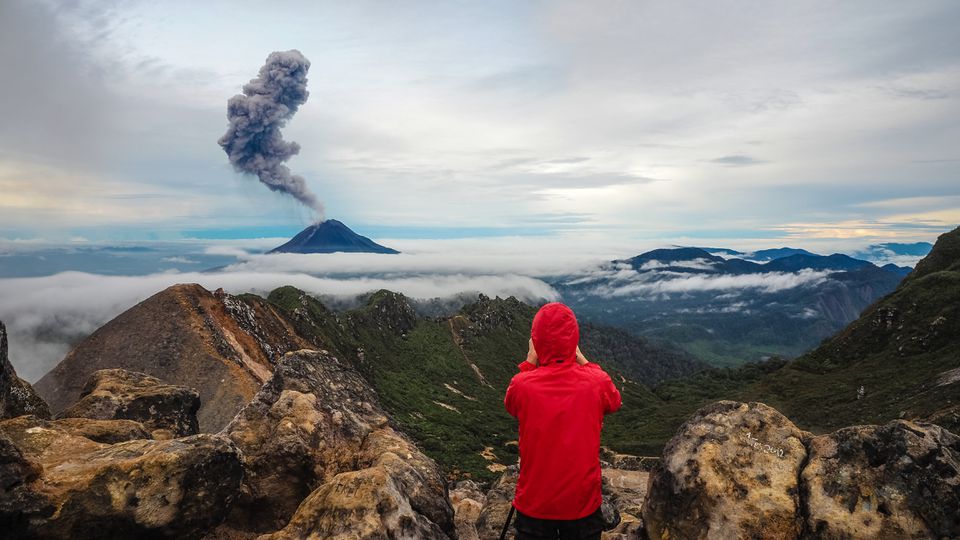 在苏门答腊徒步旅行的人看着一个活跃的火山