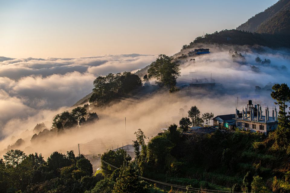 山上云雾缭绕，树木和几座建筑物