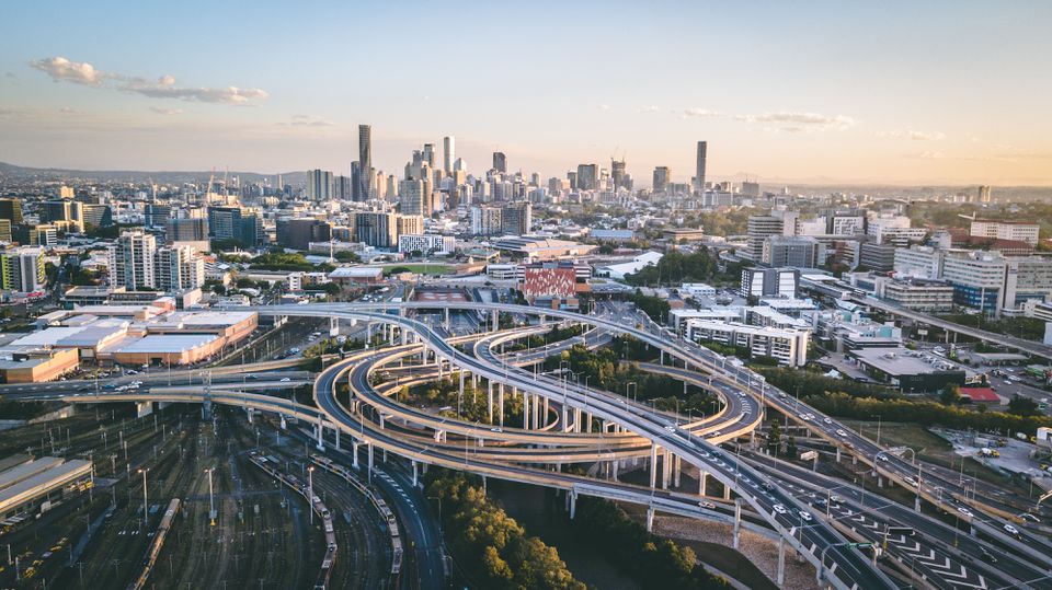 无人机拍摄的布里斯班与高速公路交叉口的前景和城市天际线的背景