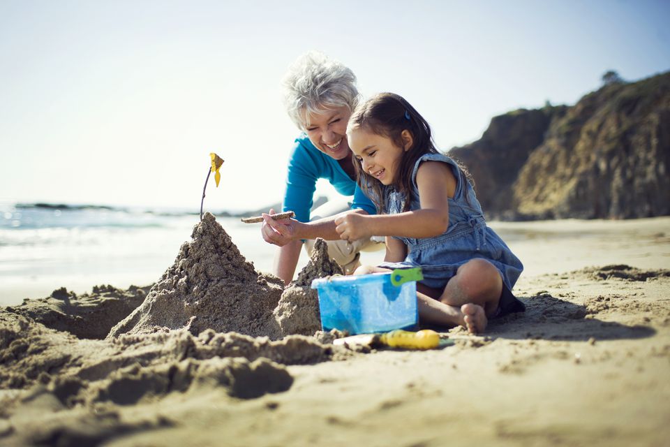 与孙子孙女、奶奶和孙子孙女在海滩上玩耍度假