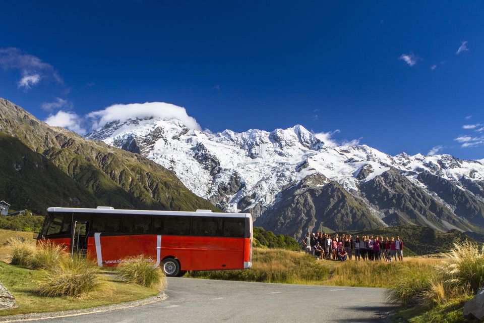 一辆旅游巴士停在新西兰库克山前。